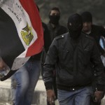 Members of the Black Bloc who oppose Egyptian President Mohamed Mursi run with Molotov cocktails during clashes with riot police, along Qasr Al Nil bridge, which leads to Tahrir Square in Cairo