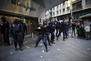 Riot police officers protect a shop from demonstrators during the general strike to protest against the government's tough new labor reforms and cutbacks, in Pamplona, northern Spain, Thursday, March 29, 2012. Pictured Corte Ingles