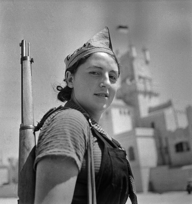 Una miliciana posa con un fusil en una foto en blanco y negro