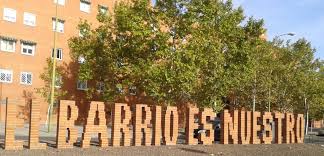 Fotografia, se ve el texto "El barrio es nuestro" fabricado con letras de ladrillo